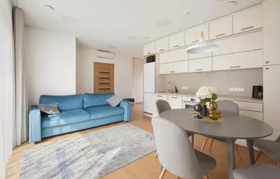 a living room with a blue couch and a table at Cozy Apartment in Kaunas
