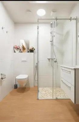a bathroom with a shower with a toilet and a sink at Cozy Apartment in Kaunas