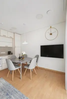 a dining room with a table and chairs and a tv at Cozy Apartment in Kaunas