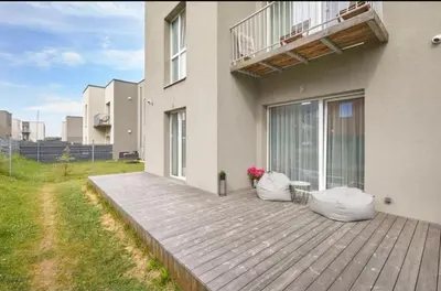 a house with two pillows on a wooden deck at Cozy Apartment in Kaunas