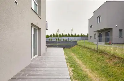 a walkway next to a building next to a field at Cozy Apartment in Kaunas