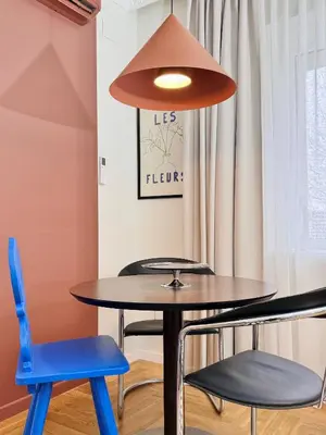a table and chairs in a room with a lamp at Cosy hill in Kaunas