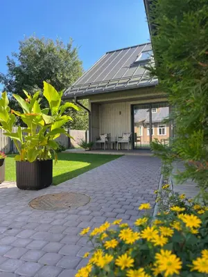 a garden with a house with a patio and flowers at Private Trakai Boutique Historical Authentic Karaim Two Floor Apartment House in Trakai
