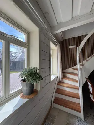 a staircase in a house with a potted plant at Private Trakai Boutique Historical Authentic Karaim Two Floor Apartment House in Trakai