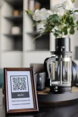 a sign sitting on a table with a vase of flowers at Skyline 1 BD Apartment by Domvia in Vilnius