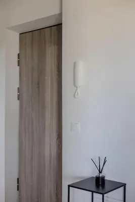 a wooden door in a room with a table at Skyline 1 BD Apartment by Domvia in Vilnius