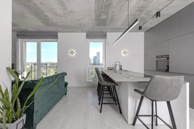 a kitchen with a counter and chairs in a room at Skyline 1 BD Apartment by Domvia in Vilnius
