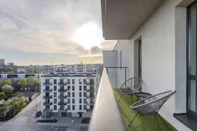 a balcony with chairs and a view of a building at Skyline 1 BD Apartment by Domvia in Vilnius