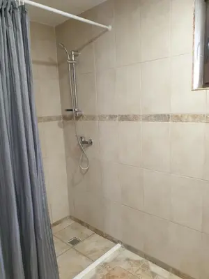 a bathroom with a shower with a shower curtain at Semeniukų Sodyba in Rakantai