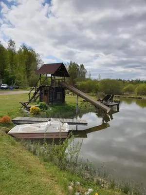 a boat on the water next to a wooden bridge at Semeniukų Sodyba in Rakantai