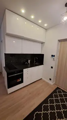 a kitchen with white cabinets and a black counter top at Vilnius Apartment in Vilnius