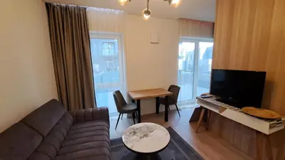 a living room with a couch and a tv and a table at Vilnius Apartment in Vilnius