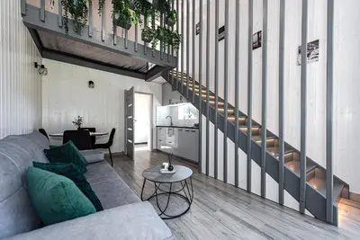 a living room with a couch and a staircase at Namelis Ramybėlė in Siauliškiai