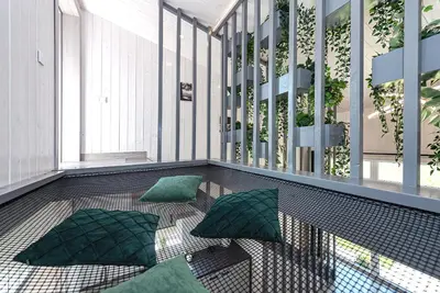a balcony with green pillows on the floor at Namelis Ramybėlė in Siauliškiai
