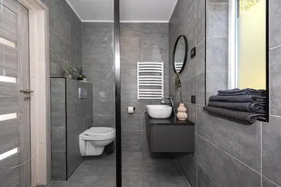 a bathroom with a toilet and a sink and a mirror at Namelis Ramybėlė in Siauliškiai