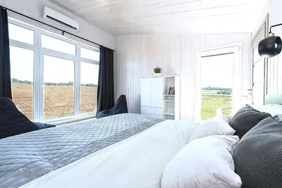 a bedroom with a large bed with a large window at Namelis Ramybėlė in Siauliškiai