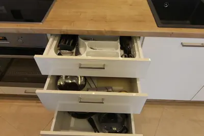a kitchen island with white drawers and a counter top at Warmzy Home near Park with Free Parking in Vilnius