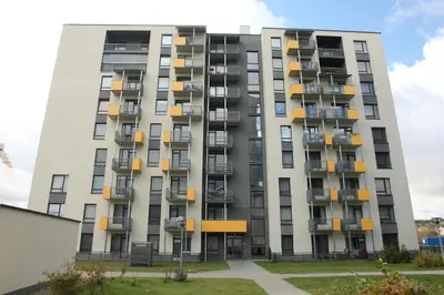 a tall apartment building with yellow balconies at Warmzy Home near Park with Free Parking in Vilnius