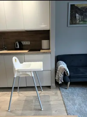 a white chair in a kitchen next to a counter at Miegu - Apartments in Druskininkai