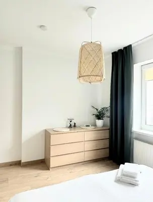 a bedroom with a bed and a sink and a window at Miegu - Apartments in Druskininkai