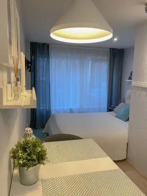 a bedroom with a bed and a table and a light at Miegu - Apartments in Druskininkai