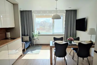 a kitchen and living room with a table and chairs at Miegu - Apartments in Druskininkai