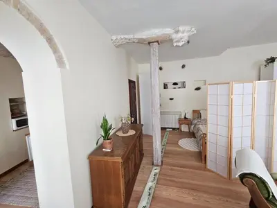 a living room with a column and a table in a room at Mykoliukas in Vilnius