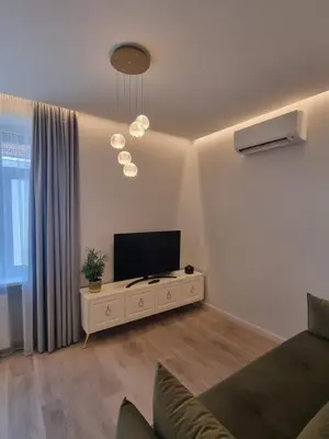 a living room with a television and a couch at Apartamentai Varpas in Šiauliai