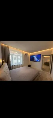 a bedroom with a large bed and a window at Apartamentai Varpas in Šiauliai