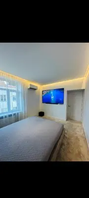 a bedroom with a large bed and a flat screen tv at Apartamentai Varpas in Šiauliai
