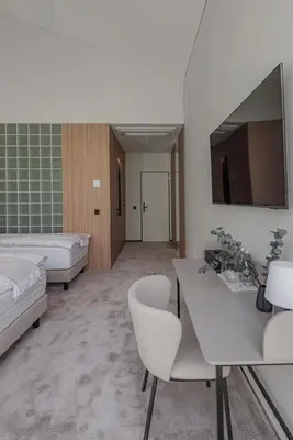 a room with a bed and a table and chairs at LAJOS Hotel in Birštonas
