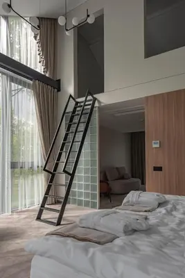 a staircase in a room with a bed at LAJOS Hotel in Birštonas