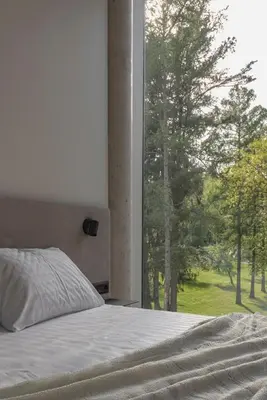 a bedroom with a bed and a large window at LAJOS Hotel in Birštonas