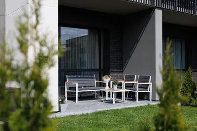 a patio with two chairs and a table and a bench at Modernus butas prie EŽERO in Vilnius