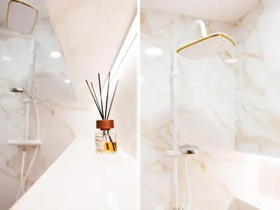 a white bathroom with a shower and a bottle of perfume at Modernus butas prie EŽERO in Vilnius