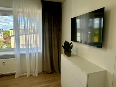 a living room with a tv and a window at Draugystės apartamentai II in Šiauliai