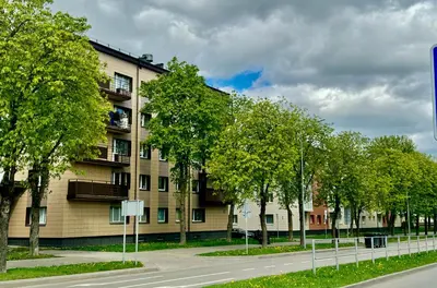 a building with trees on the side of a street at Draugystės apartamentai II in Šiauliai