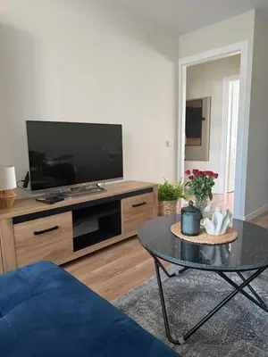 a living room with a tv and a coffee table at NESTAa in Druskininkai