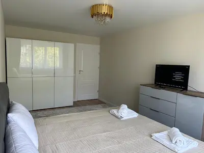 a bedroom with a bed and a tv on a dresser at NESTAa in Druskininkai