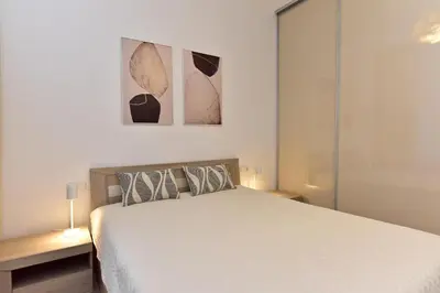 a bedroom with a bed and two pictures on the wall at Apartamentai DU in Druskininkai