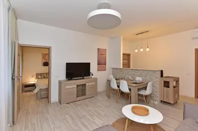 a living room with a table and a television at Apartamentai DU in Druskininkai