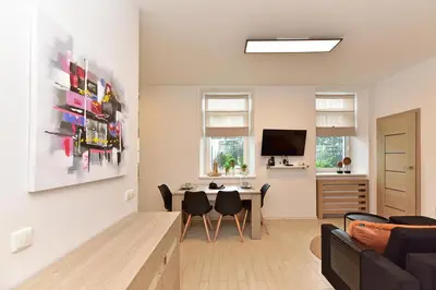 a living room with a table and a tv at Apartamentai DU in Druskininkai