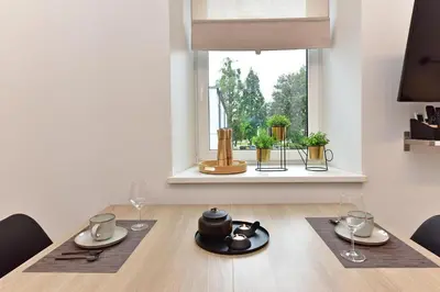 a dining room with a table and a window at Apartamentai DU in Druskininkai