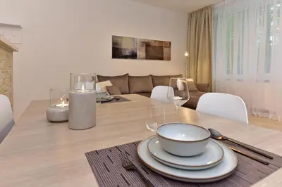 a dining table with glasses and a bowl on it at Apartamentai DU in Druskininkai