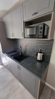 a kitchen with a sink and a microwave at Trumpalaikė butų nuoma Kaune prie Klinikų SELF CHECK-IN in Kaunas