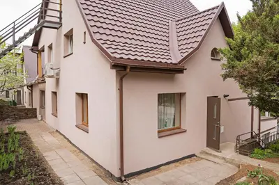 a white house with a brown roof at Compact and Comfy Apartment on the Greenhill in Kaunas