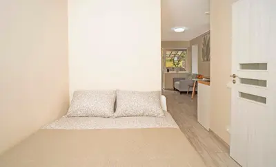 a bedroom with a bed and a hallway at Compact and Comfy Apartment on the Greenhill in Kaunas