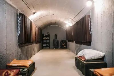 a long hallway with two beds in a tunnel at Pinčiukas Bunkeris in Dagiai