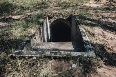 a hole in the ground in a field at Pinčiukas Bunkeris in Dagiai