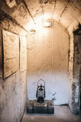 a tunnel with a lantern in the corner of a room at Pinčiukas Bunkeris in Dagiai